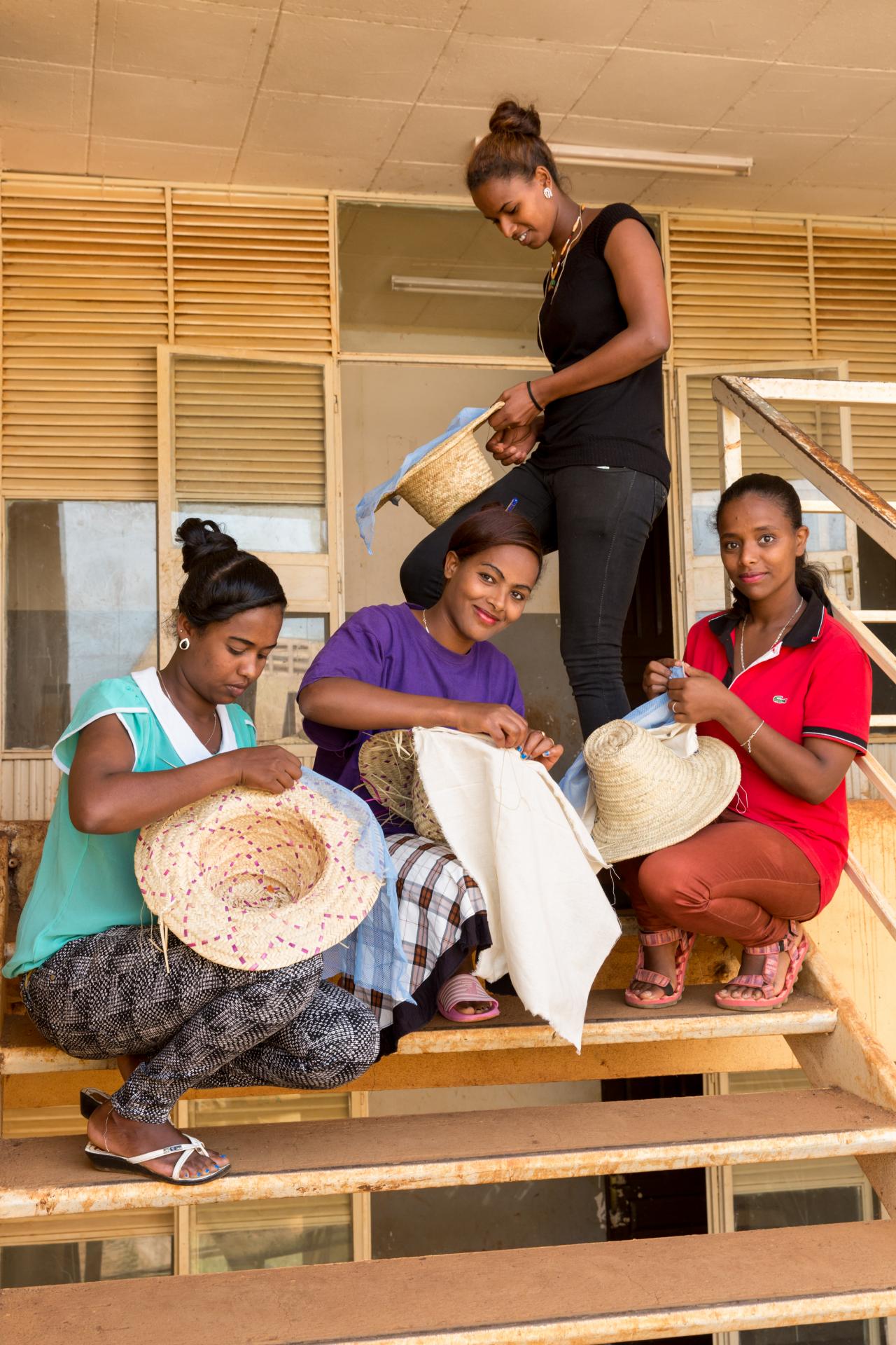 students sewing hats